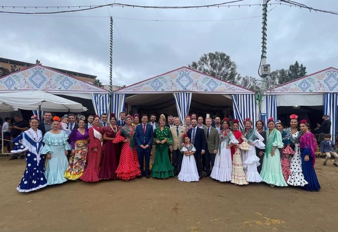 El concejal de Cultura y Patrimonio Arqueológico del Ayuntamiento de Huelva, Nacho Molina (con traje de chaqueta azul), junto a la alcaldesa de Huelva, Pilar Miranda (con traje verde), en la caseta ganadora del concurso de decoración.