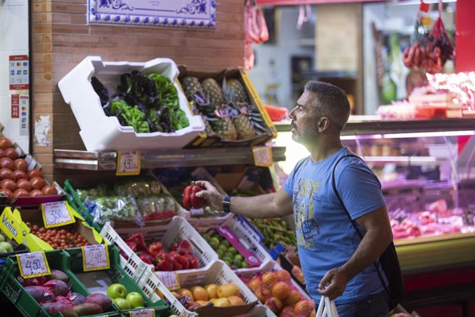 Archivo - Un hombre comprando en un mercado de abastos de Triana (Sevilla).