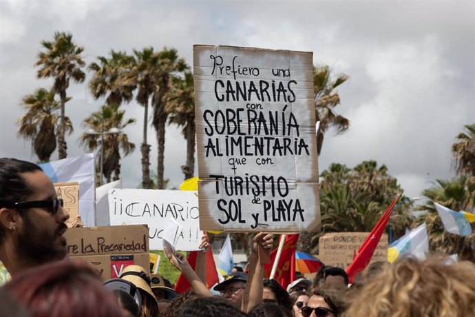 Archivo - Una persona sujeta un cartel de protesta durante una manifestación contra el modelo turístico, a 20 de abril de 2024, en Las Palmas de Gran Canaria, Gran Canaria, Canarias (España)