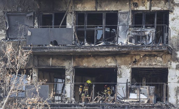 Archivo - Arxiu - Dos agents de la Policia Científica cerquen les causes de l'incendi en l'edifici del barri de Campanar