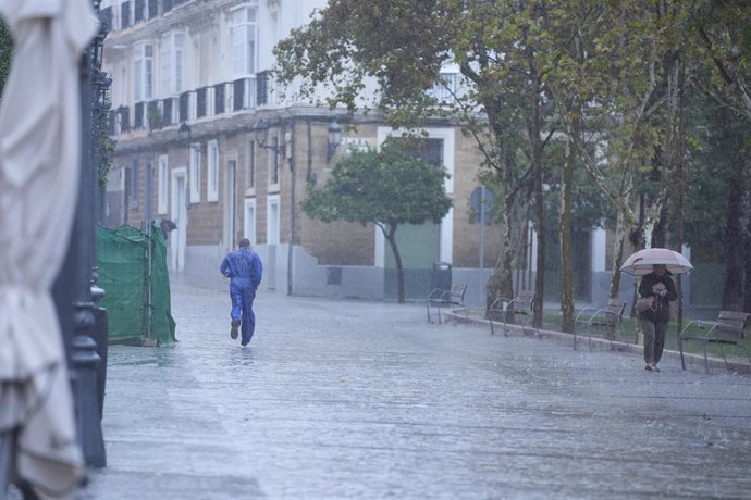 Transeuntes bajo sus paraguas durante la intensa lluvia. A 11 de octubre de 2024, en Cádiz (Andalucía, España). 