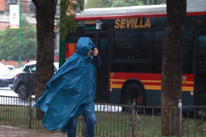 Archivo - Una persona se protege de la lluvia con su impermeable. Imagen de archivo. 