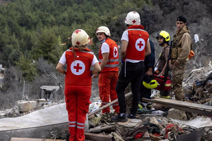 October 15, 2024, Aitou, Lebanon: Lebanese Red Cross medics and other searchers stand on the rubble after an Israeli attack leveled a residential building housing displaced people on October 15, 2024 in Aitou, Lebanon. The Lebanese Red Cross medics contin