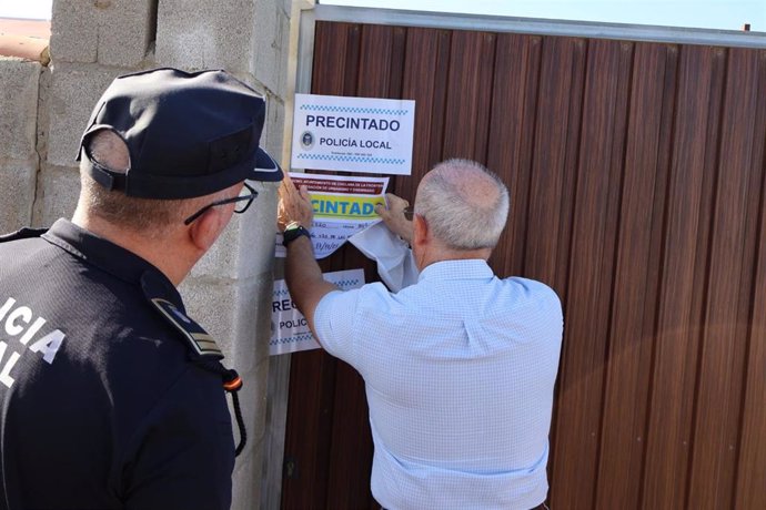 Un inspector de la Delegación de Urbanismo y un agente de la Policía Local de Chiclana durante el precinto de una subparcela ilegal.