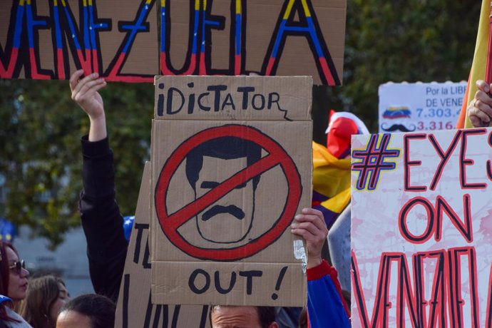 September 28, 2024, London, United Kingdom: A protester holds a placard calling Maduro a 'dictator' during the demonstration. Members of the Venezuelan community gathered in Parliament Square for a protest against President of Venezuela, Nicolas Maduro.