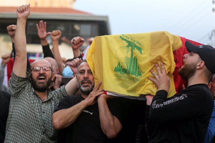 Imagen de archivo de varios hombres cargando un féretro cubierto con la bandera de Hezbolá durante un funeral.