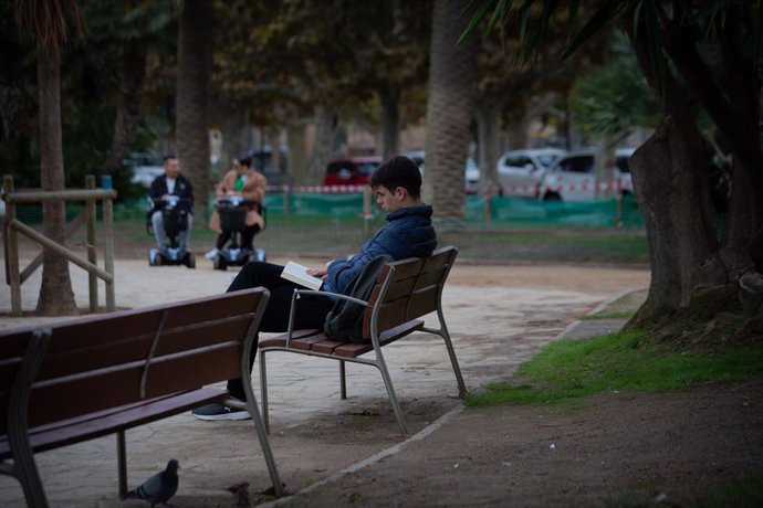 Archivo - Un joven lee un libro en el Parque de la Ciutadela, a 12 de noviembre de 2021, en Barcelona, Cataluña (España).