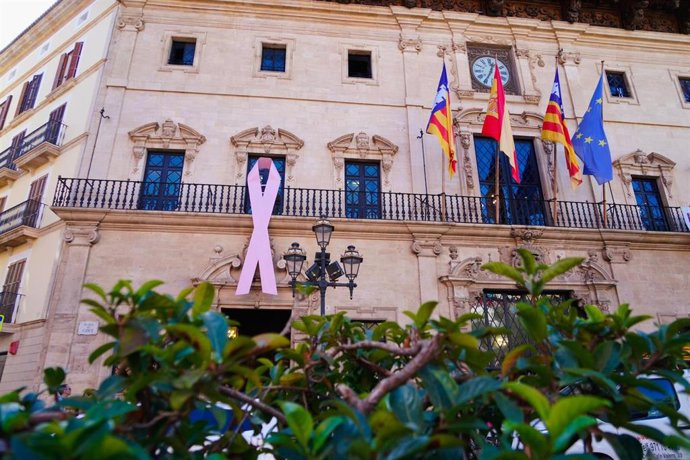El balcón de Cort luce un lazo rosa por el Día Mundial contra el Cáncer de Mama.