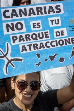 Archivo - Una persona sujeta un cartel de protesta durante una manifestación contra el modelo turístico, a 20 de abril de 2024, en Las Palmas de Gran Canaria, Gran Canaria, Canarias (España). Las ocho islas canarias se unen hoy para protestar contra la ma