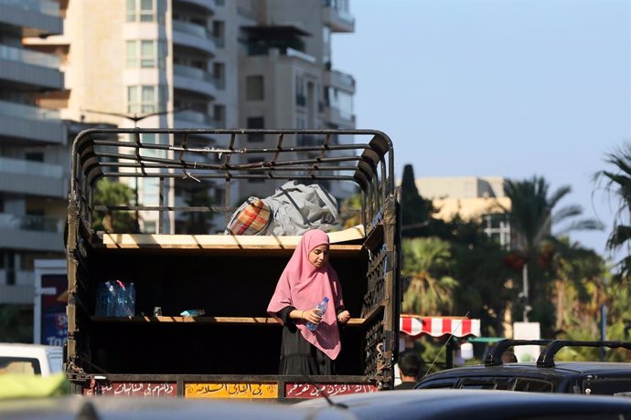 04 October 2024, Lebanon, Beirut: A girl, who fled with her family Beirut southern suburb, stands inside a small van as she arrives to take refuge along Beirut promenade. At least 1.2 million Lebanese have fled south Lebanon, the capital southern suburb a