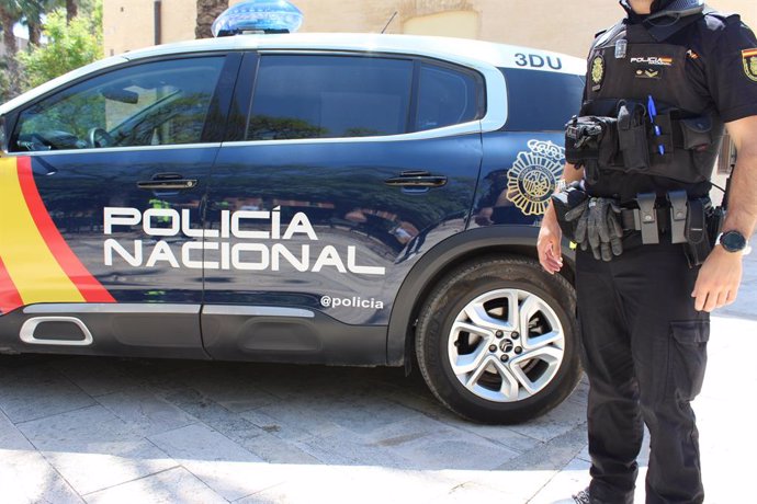 Agent junt amb vehicle policial