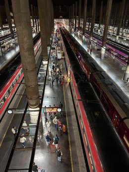 Diverses persones en l'andana esperen per a muntar en el tren