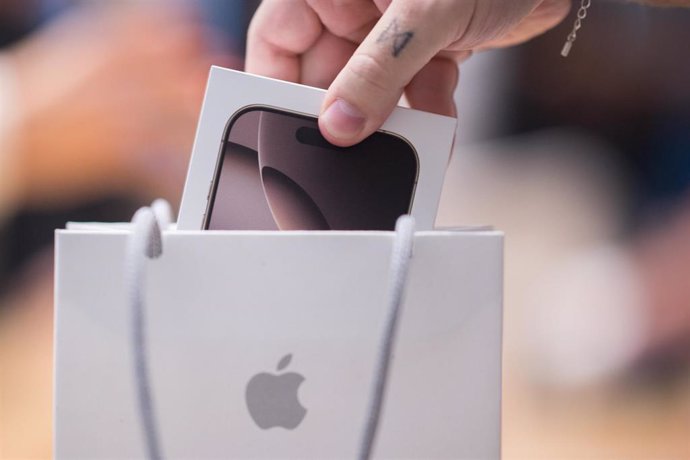 Archivo - 20 September 2024, Berlin: An employee packs a new iPhone 16 in an Apple store. 