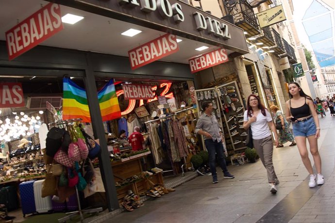 Archivo - Varias personas caminan con bolsas en las rebajas de este verano