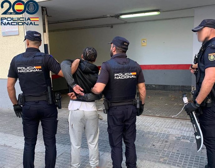 Agentes de la Policía Nacional de Palma con el detenido y el machete con el que cometió la agresión.