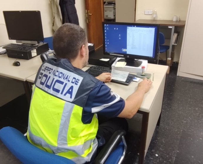 Un agente de Policía Nacional frente a un ordenador.