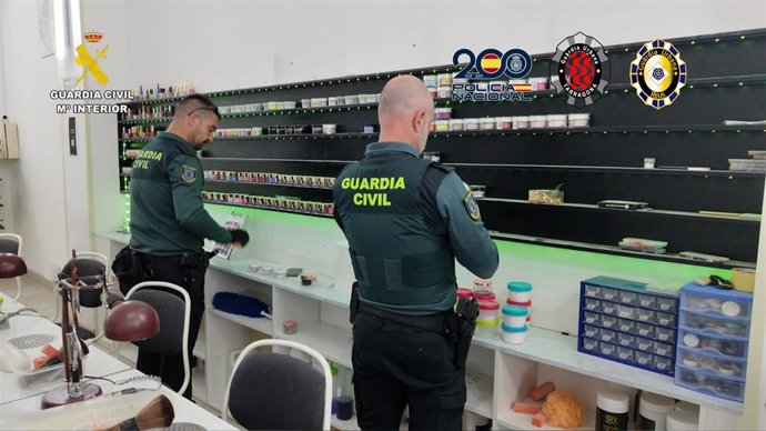 Dos agentes de la Guardia Civil durante la inspección de uno de 11 locales de manicura y centros de belleza de Tarragona y Reus