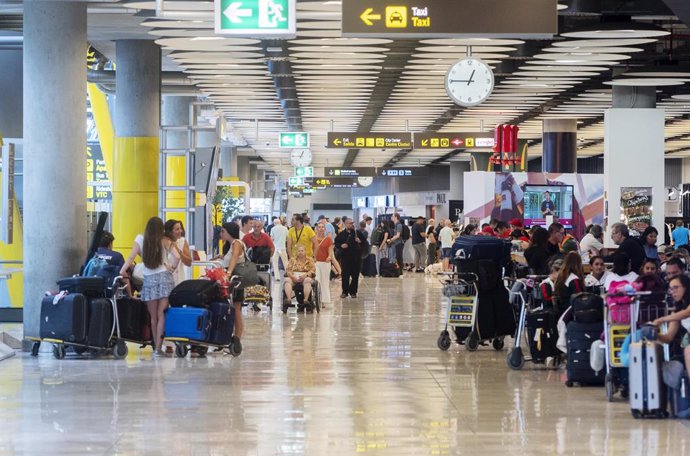 Archivo - Varias personas con maletas en la terminal T4 del aeropuerto Adolfo Suárez Madrid-Barajas.