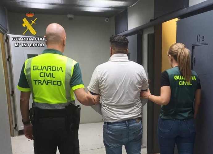 Dos agentes de la Guardia Civil custodian al detenido