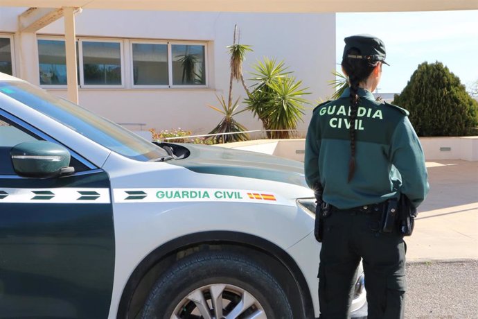 Agente de la Guardia Civil junto a un vehículo