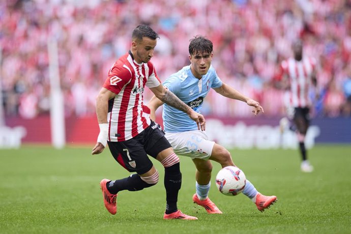 Alex Berenguer of Athletic Club competes for the ball with Javi Rodriguez of RC Celta de Vigo during the LaLiga EA Sports match between Athletic Club and RC Celta de Vigo at San Mames on September 22, 2024, in Bilbao, Spain.