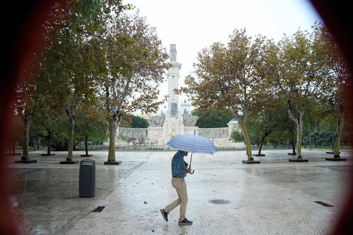 Transeuntes bajo sus paraguas durante la intensa lluvia. A 11 de octubre de 2024, en Cádiz (Andalucía, España). La Agencia Estatal de Meteorología (Aemet) ha activado para este viernes avisos de nivel naranja por lluvia y amarillo por tormenta en la mitad