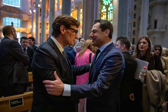Archivo - El presidente de la Junta de Andalucía, Juanma Moreno, saluda a Salvador Illa en la misa rociera en la Sagrada Familia, a 18 de marzo de 2023, en Barcelona. (Foto de archivo).
