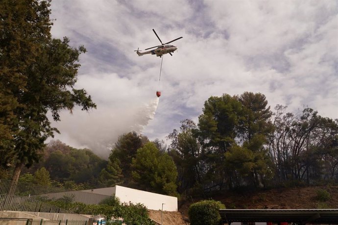 Un helicóptero  del Infoca arroja agua sobre el incendio, a 7 de octubre de 2024, en Málaga, Andalucía (España).  