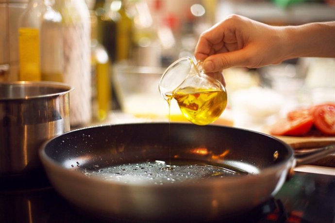 Archivo - Cocinar vertiendo aceite de oliva en una sartén