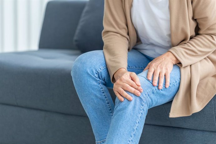 Archivo - Woman suffering from knee pain sitting sofa in the living room, Mature woman suffering from knee pain while sitting on the sofa