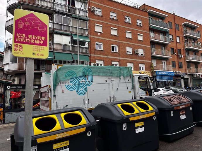 Señales de la campaña 'Usera, tu casa' del Ayuntamiento de Madrid junto a contenedores