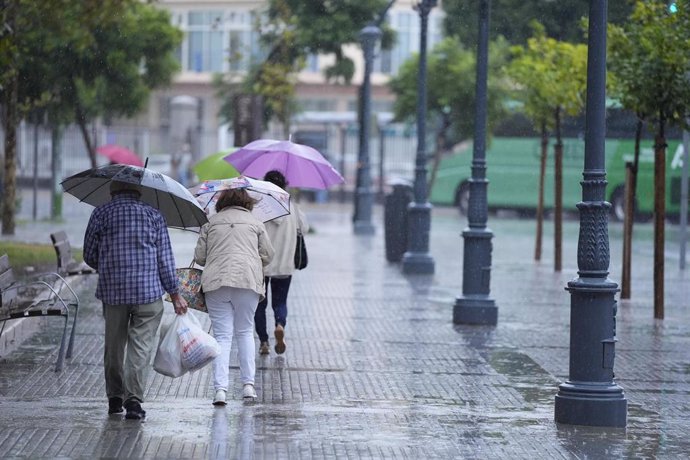 Transeuntes bajo sus paraguas durante la intensa lluvia en Cádiz. (Imagen de archivo).