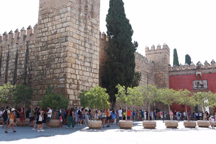 Archivo - Turistas en la Plaza del Triunfo guardan cola y se disponen a entrar en el Real Alcázar de Sevilla. 