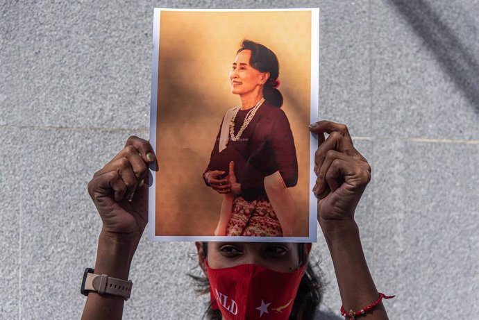 Archivo - Un manifestante sostiene un retrato de Aung San Suu Kyi durante una manifestación ante la Embajada de Birmania en Bangkok.