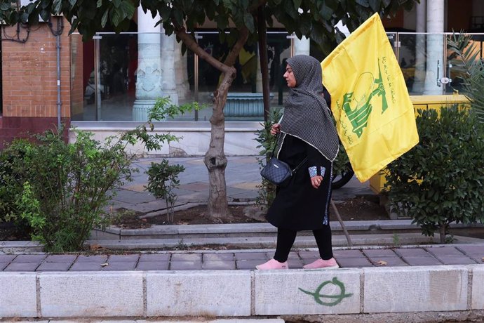 Una mujer en Irán con una bandera del partido-milicia chií libanés Hezbolá