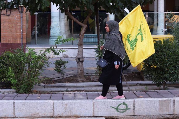 September 30, 2024, Tehran, Tehran, Iran: A mourner holds up a Hezbollah flag during a rally commemorating slain Hezbollah leader Hassan Nasrallah at Enqelab-e-Eslami (Islamic Revolution) St. in downtown Tehran, Iran, Monday, Sept. 30, 2024.