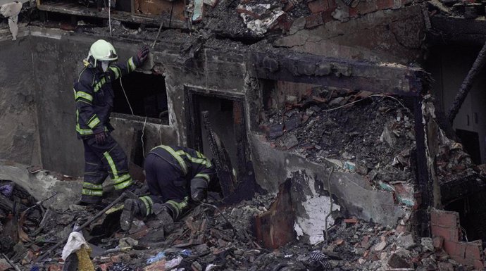 Agentes del equipo de bomberos trabaja en el edificio derrumbado