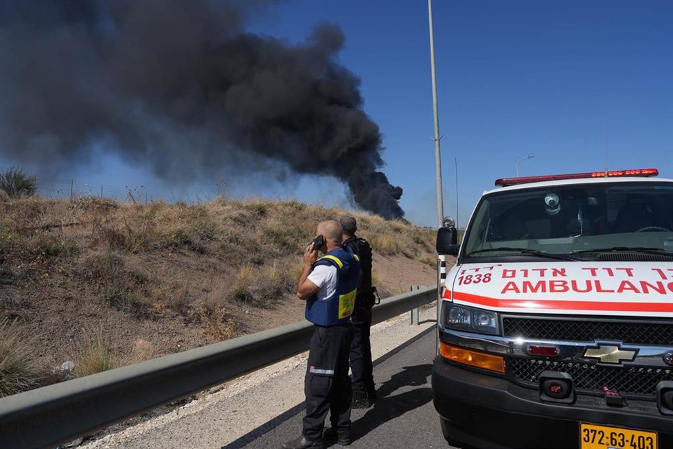 Trabajadores sanitarios israelíes observan el impacto de un cohete de Hezbolá