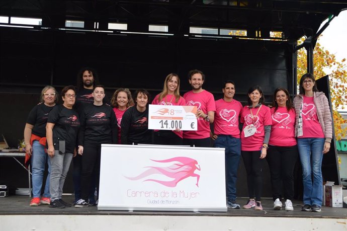 El alcalde de Monzón, Isaac Claver, junto al concejal de Deportes, Eliseo Martín, entrega el cheque de 14.000 euros a la investigadora Marta Basegla en nombre del equipo de Oncología Molecular en la VIII Carrera de la Mujer de Monzón .