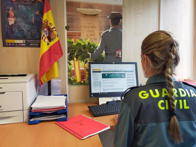 Archivo - Una agente de la Guardia Civil investiga en un ordenador