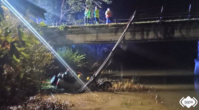 Efectivos de bomberos rescatan el vehículo del río del hombre fallecido en el siniestro.