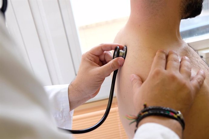 Archivo - Un médico atiende a un paciente en el Virgen del Rocío. (Imagen de archivo).