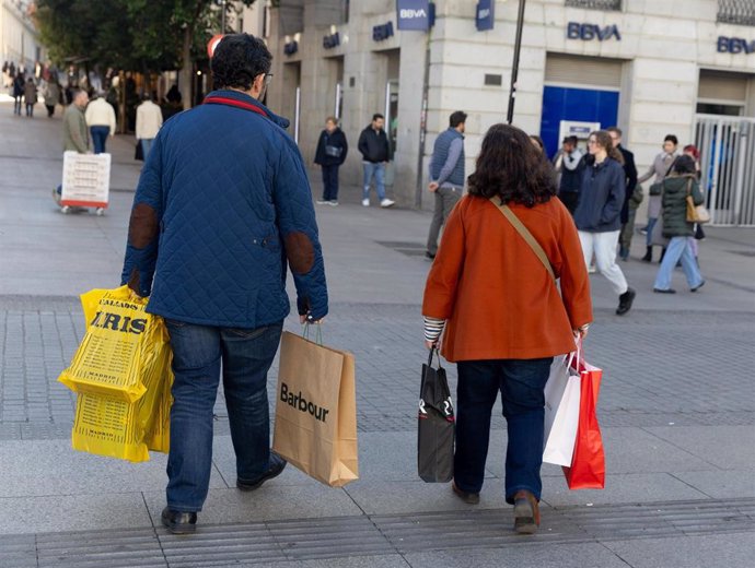 Archivo - Dos personas llevan varias bolsas de compra durante Black Friday, a 24 de noviembre de 2023, en Madrid (España).