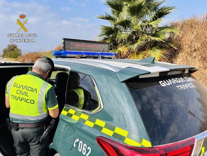 Imagen de archivo de un coche y agente de la Guardia Civil de Tráfico.