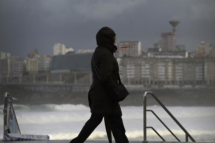 Archivo - Una mujer se cubre con la capucha durante el frente meteorológico, a 23 de febrero de 2024, en A Coruña, Galicia (España). La Agencia Estatal de Meteorología (Aemet) decretó un aviso naranja por temporal costero en el litoral gallego que ya es