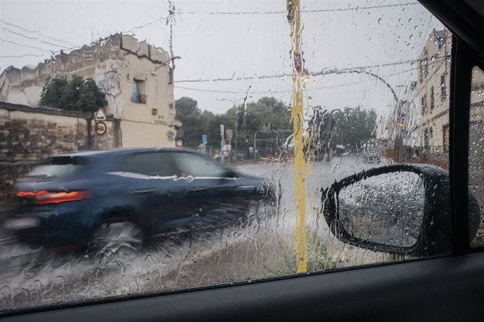 Archivo - Un coche circula bajo la lluvia