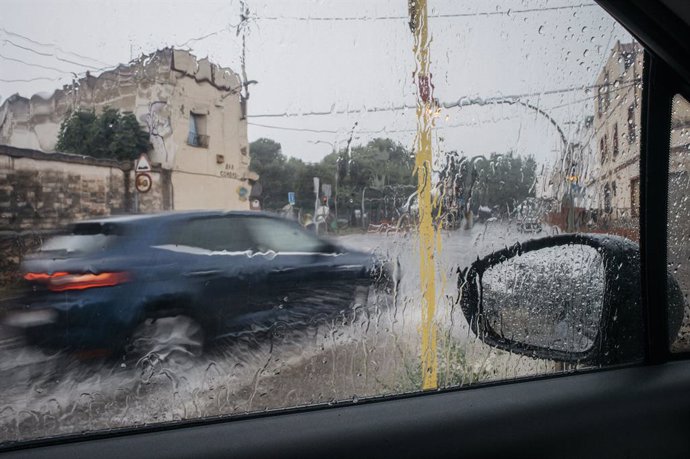 Archivo - Arxiu - Un cotxe circula baix la pluja