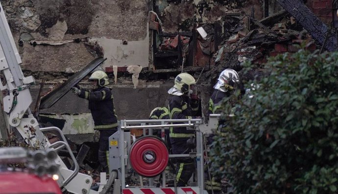 Agentes del equipo de bomberos trabaja en el edificio derrumbado