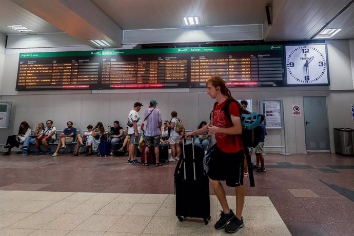 Archivo - Varias personas junto a sus maletas frente al panel de salidas, con motivo de la operación salida del puente de agosto, en la estación de tren de Chamartín, a 14 de agosto de 2024, en Madrid (España). Renfe ofrece cerca de 1,8 millones de plazas