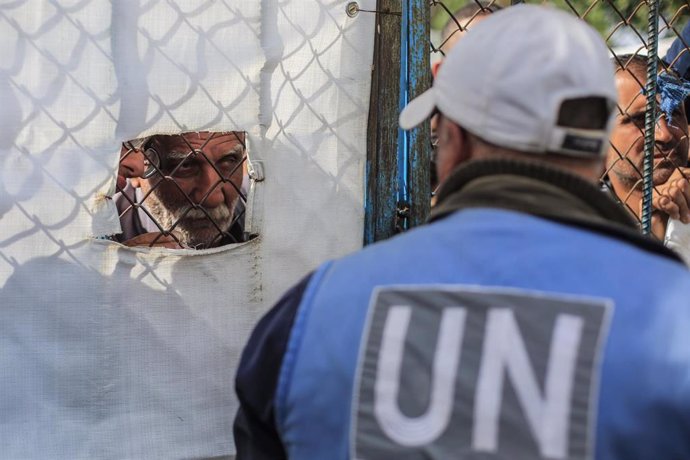 Archivo - Imagen de archivo de un trabajador de la UNRWA supervisando la entrega de ayuda a palestinos en un centro de distribución de la organización. 